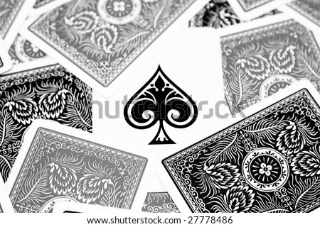 Ace of spades hidden between black and grey playing cards