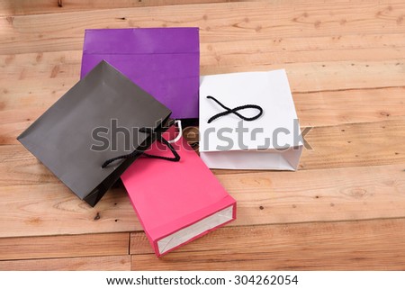 Paper shopping bags isolated on wood background