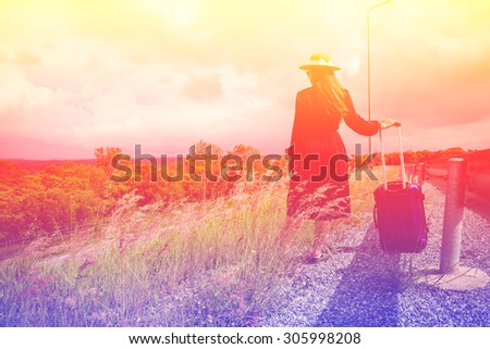Women dressed in black with purple travel wallet,Traveling by road.