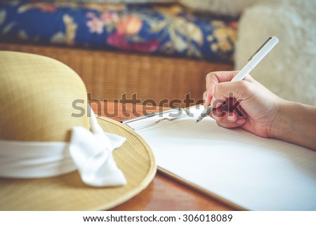 Close-up of hand holding pen and writing in diary of hand writing in diary,Vintage Style