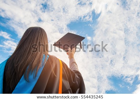 Graduates of the University,Of graduates holding hats handed to the sky.