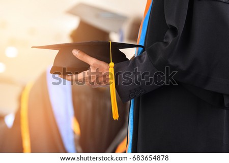 University graduates holding a hat in ceremony