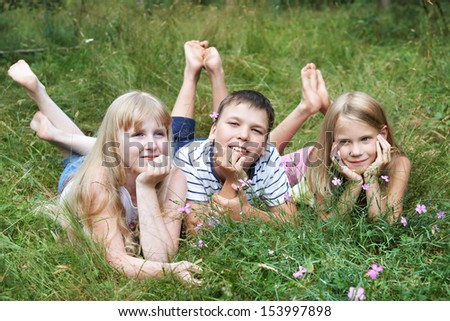Happy children lying on the grass on a sunny summer day
