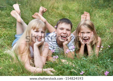Happy children lying on the grass on a sunny summer day