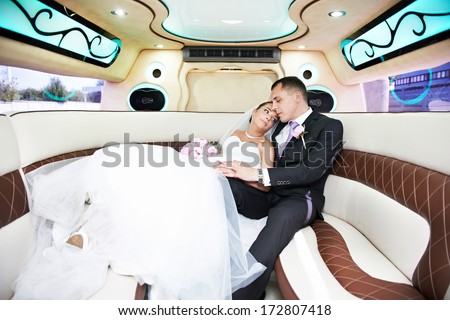 Bride and groom in wedding limousine