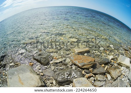 Letters Sea on stone of shore on summer day