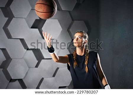 Active playing girl with a basketball on cell gray background