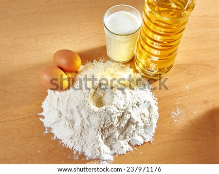 Still life of flour, milk and eggs, sunflower oil on table