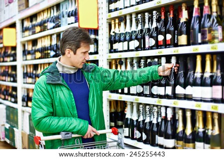 Man choosing red wine in supermarket