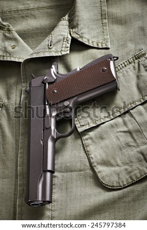Colt pistol lie on military jacket closeup