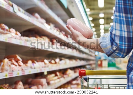 Woman buys a boiled sausage in the supermarket