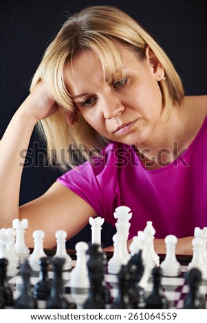 Woman playing chess on black background