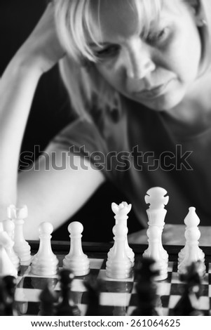 Woman playing chess white and black