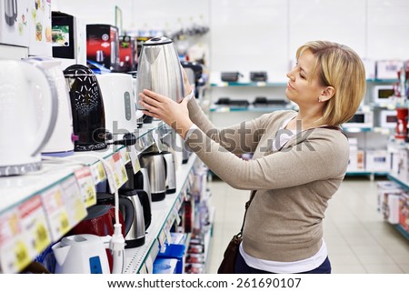 Woman housewife shopping for electric kettle, smiling