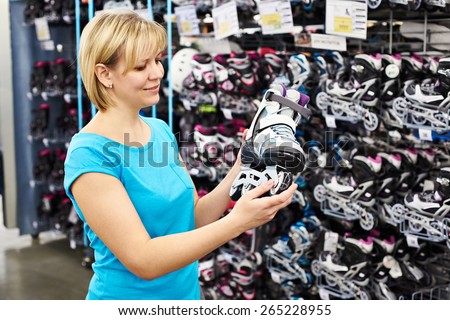 Woman chooses roller skates in the sports shop