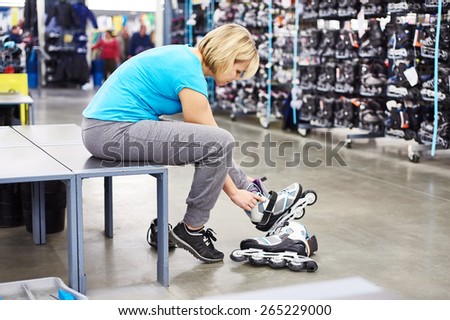 Woman wears roller skates in the sports shop