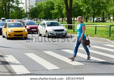 Woman crossing the street at a pedestrian crossing