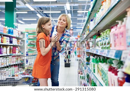Mother and daughter sniff fragrance shampoo in supermarket