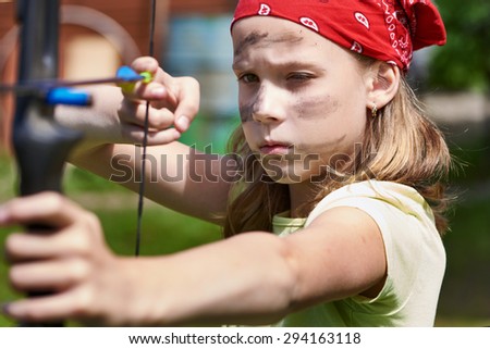 Girl archer with bow shooting to sport aim in sunny summer day