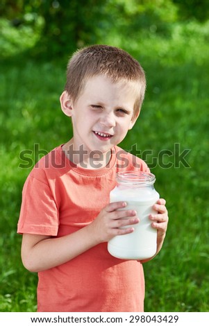 Happy boy with jug of milk in sunny garden