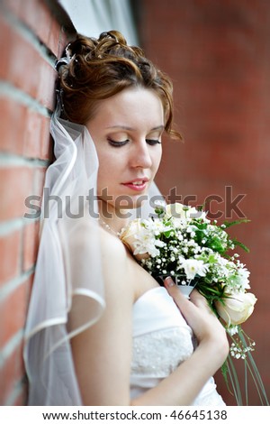 Elegant bride of the brick wall at the wedding walk