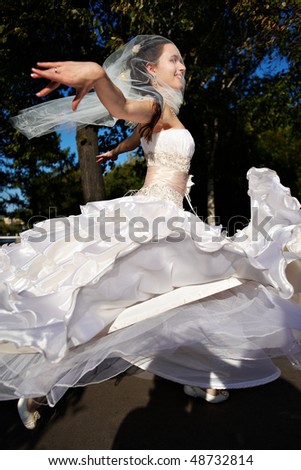 Happy bride wedding dancing in summer park