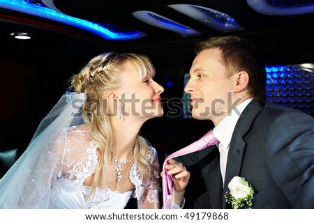 Happy bride and groom in a wedding limousine