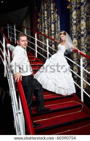 Bride and groom on the red stairs on banquet