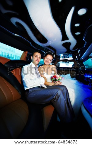 The bride and groom in a luxury wedding limousine