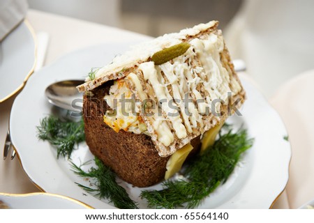 Dish of bread and a salad in the shape of the house. Funny cooking.