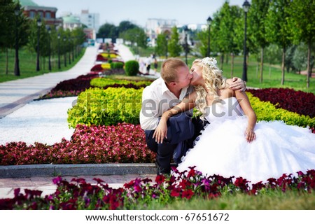 Happy bride and groom at a wedding a walk in the park surrounded by flowers