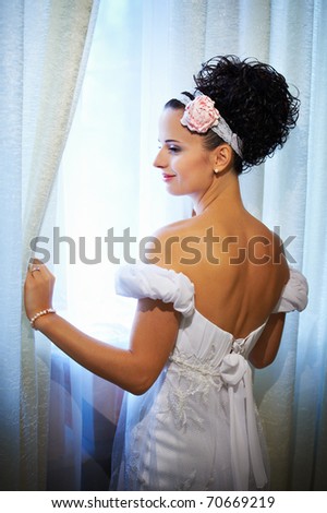 stock photo Happy bride in wedding dress near sunny window