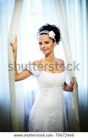 stock photo Happy bride in wedding dress near sunny window