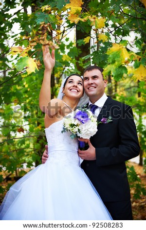 Joyful bride and groom in yellow autumn foliage on wedding walk