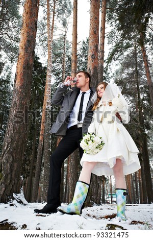  Bride and groom with champagne glasses in winter forest in wedding day