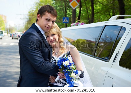 Happy bride and groom about limousine in wedding day