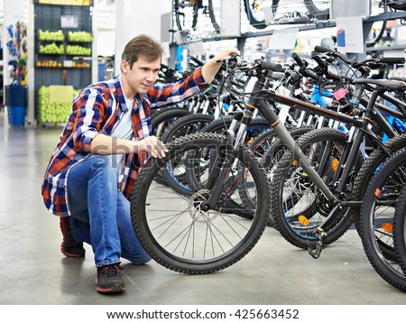 Man checks bike before buying in sports shop