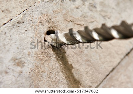 Big drill bit in hole of concrete closeup