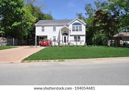 Suburban Two Story High Ranch Home Designer Driveway Parked Cars Sunny Blue Sky Day