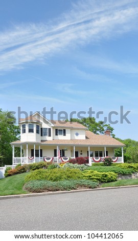 Large Suburban Home Decorated with American Flags for Memorial Day and July 4 Independence Holiday Sunny Blue Sky Day