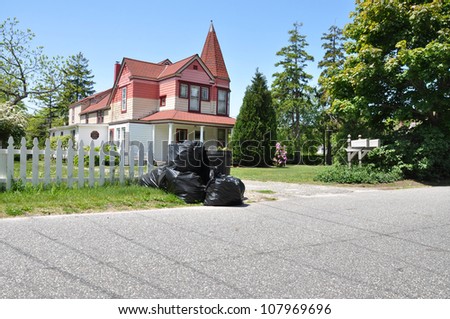 Trash Day Street Curb Victorian Style Home in Suburban Residential Neighborhood Blue Sky sunny day