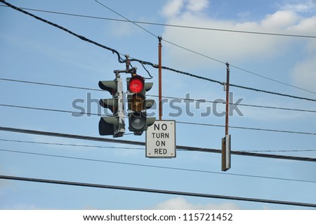 Red Traffic Light and No Turning on Red Sign Cables Wires Blue Sky Clouds
