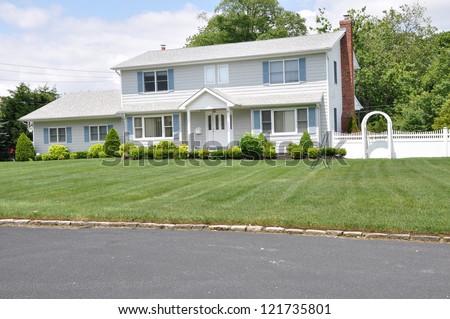 Suburban High Ranch Home landscaped front yard lawn sunny day with clouds