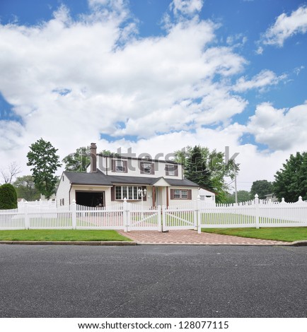 Suburban High Ranch White Picket Fence Brick Driveway Residential Neighborhood Street Blue Sky Clouds