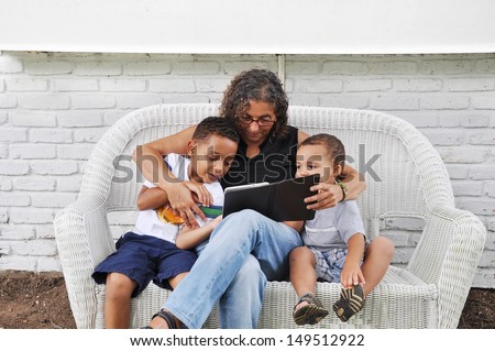 Two Generation Family Reading Mature Woman and Two boys