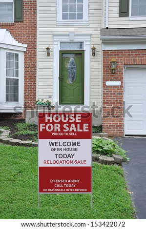 House for Sale Real Estate Sign on front yard lawn of Suburban home USA