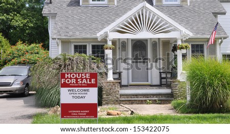 Real Estate For Sale Sign Front Yard Lawn of Suburban Home Cottage Style Home Residential Neighborhood