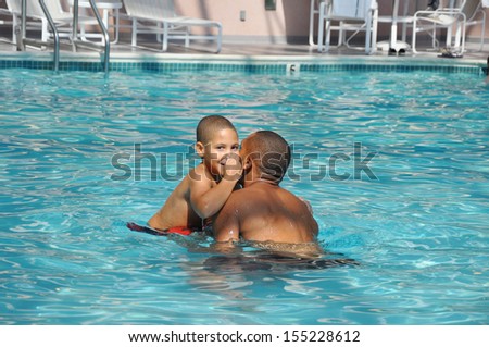 Two Generation Family Father holding  Son Swimming Pool preparing to do somersault