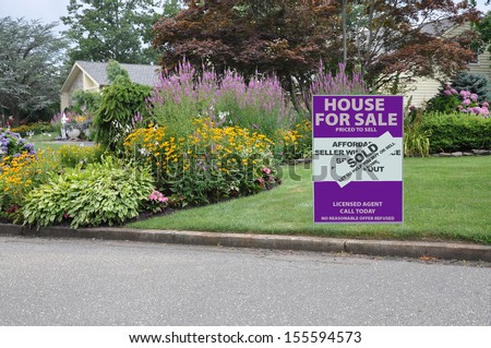 Real Estate House for Sale Sold Sign on home front yard lawn curb near flower garden in suburban residential neighborhood