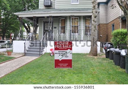 Real Estate For Sale Sold Sign front yard lawn home lined with black plastic trash cans USA